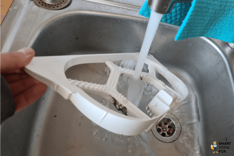 Die Noppenplatte der Dreame L10s Ultra Basisstation wird unter fließendem Wasser gereinigt.